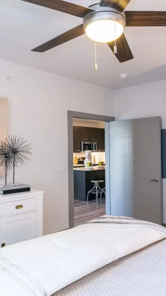 a bedroom with a ceiling fan and white bed at The Argon